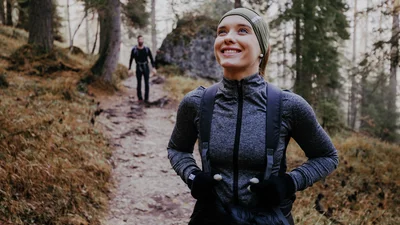 Kvinna löptränar i skogen.