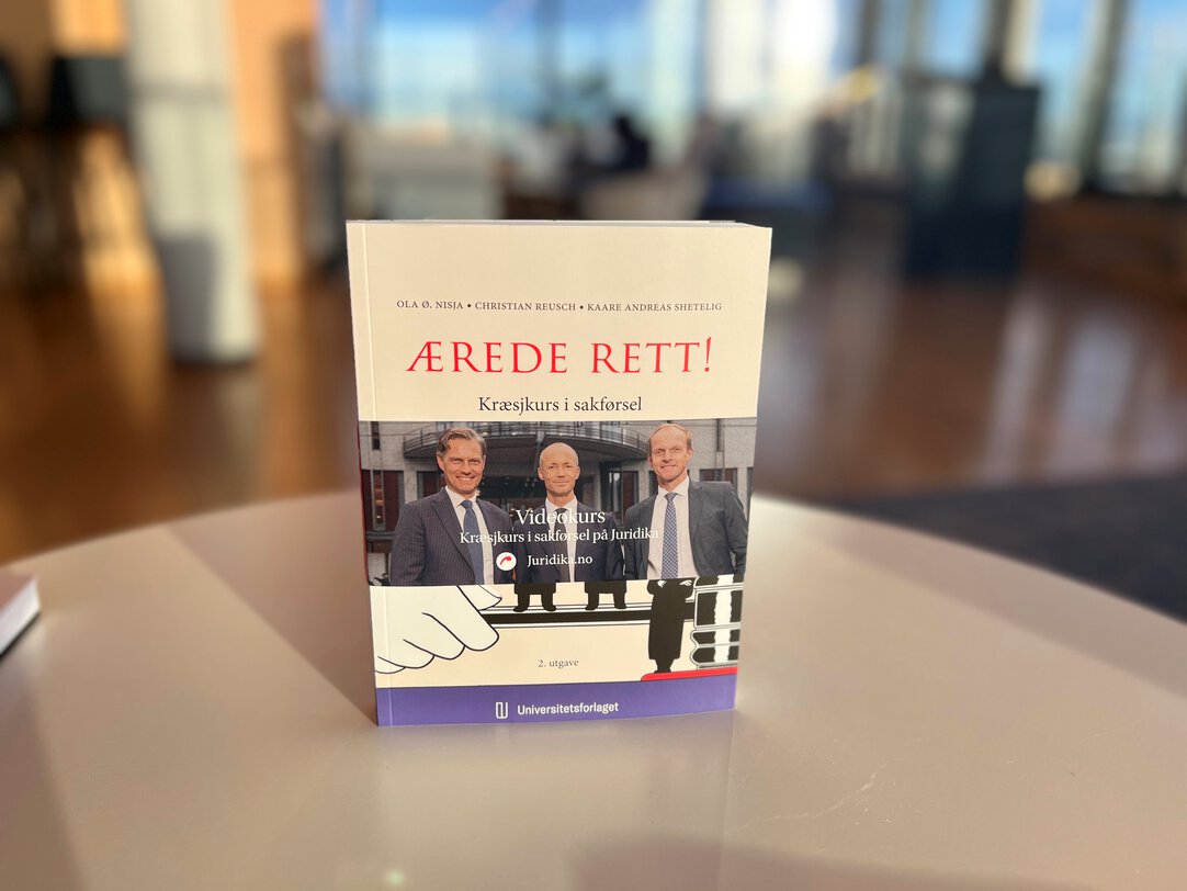 Close-up of Ola Ø. Nisja and Kaare Andreas Shetelig holding their new book Ærede Rett!
