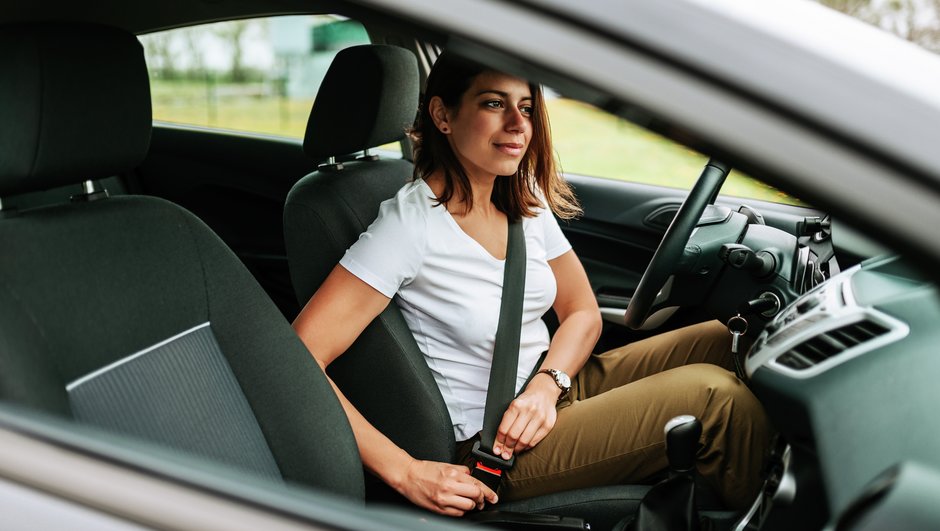 Kvinde spænder sikkerhedssele i en bil