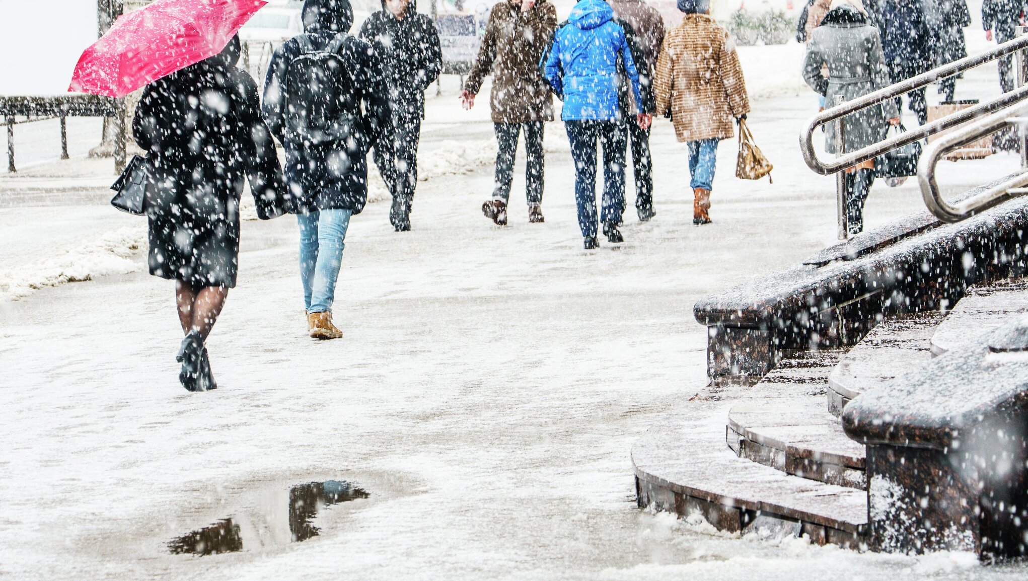 people walking in a snowy pavement.