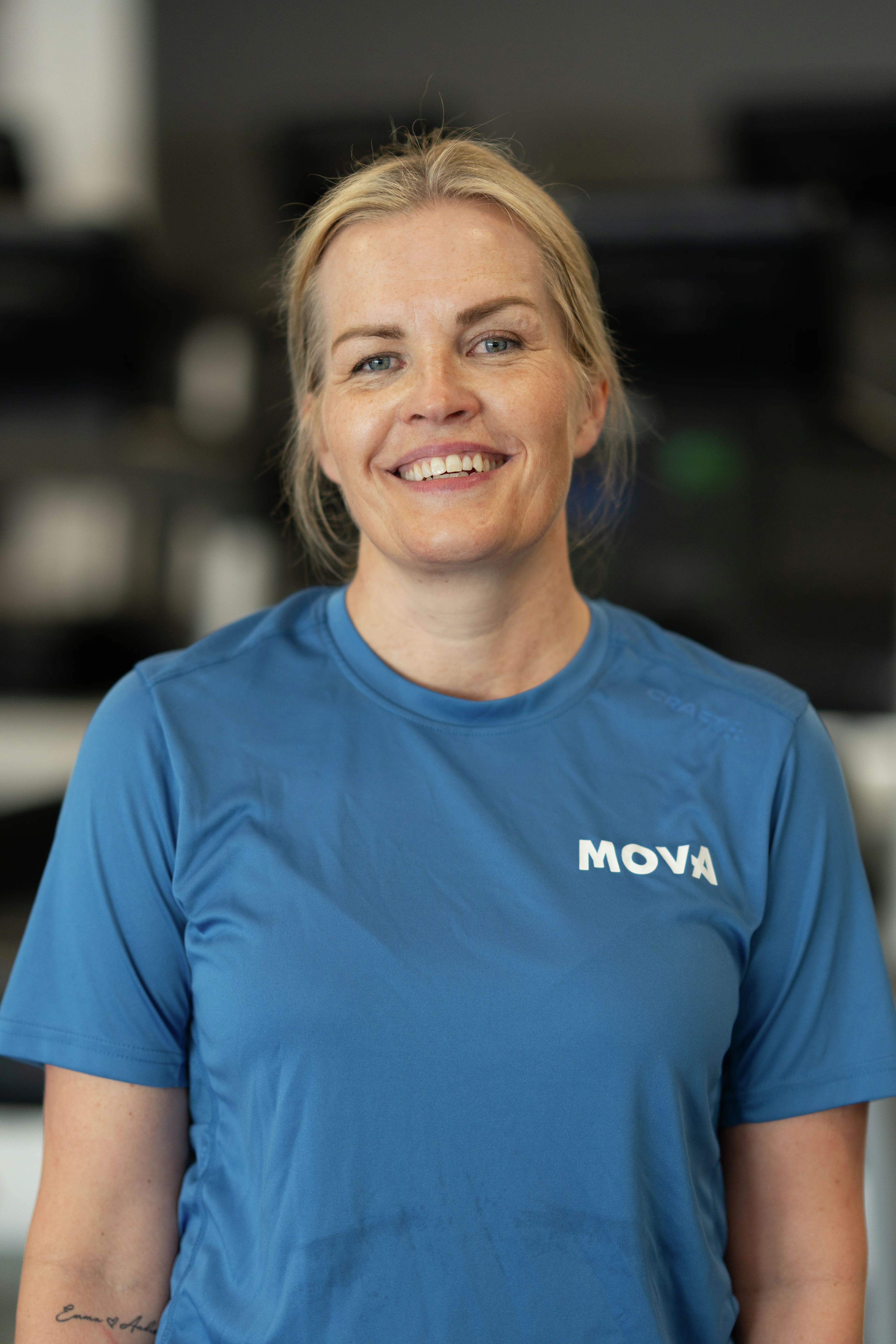 Portrett av smilende ansatt Marianne i blå MOVA-t-skjorte på MOVA Mathopen.