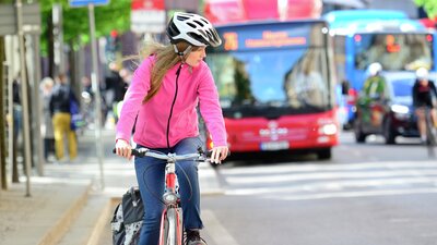 Nainen pyöräilee liikenteen seassa