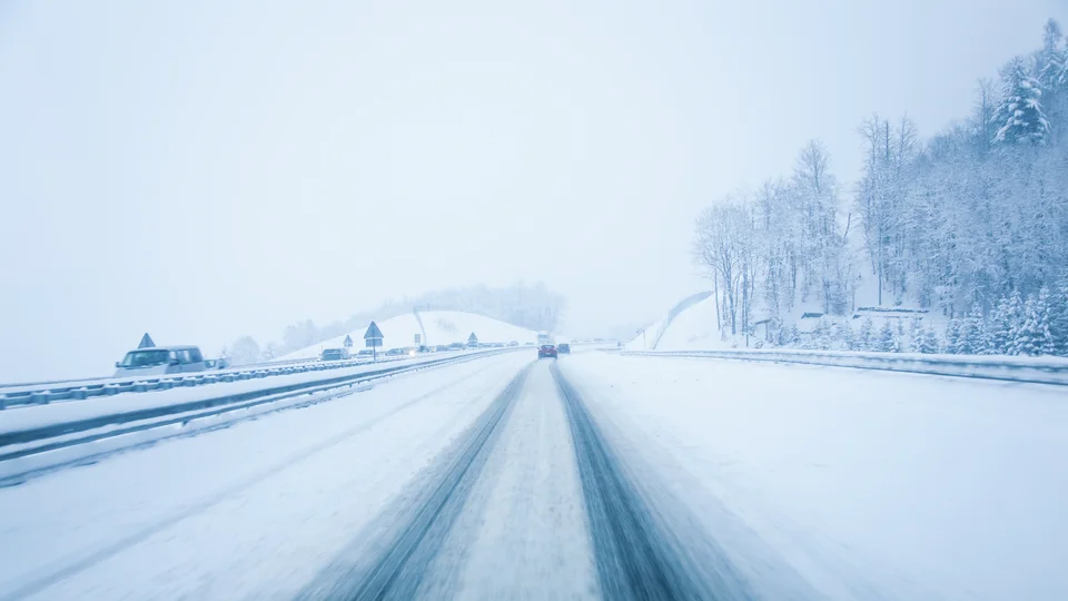 Bil kör på snöig motorväg