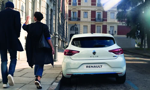 Man och kvinna går förbi vit parkerad Renault