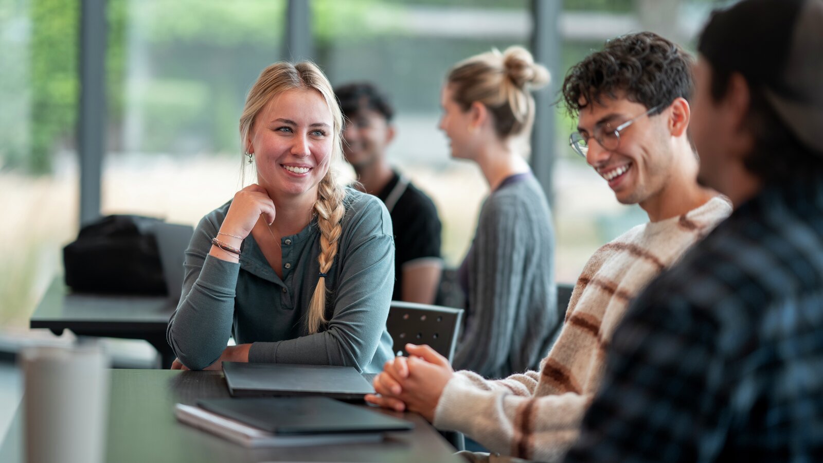 Group of Diverse Students Engaging in Friendly Discussion in Bright Class
