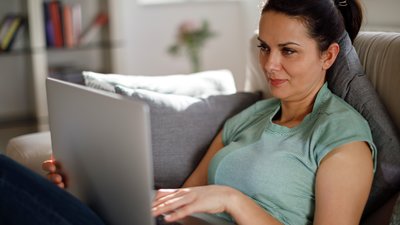 kvinna läser på bärbar dator