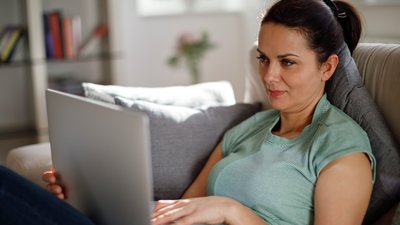 kvinna läser på laptop