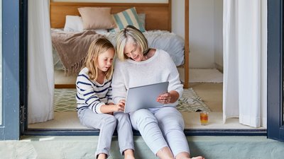 Nainen ja lapsi katsovat kannettavan tietokoneen näyttöä