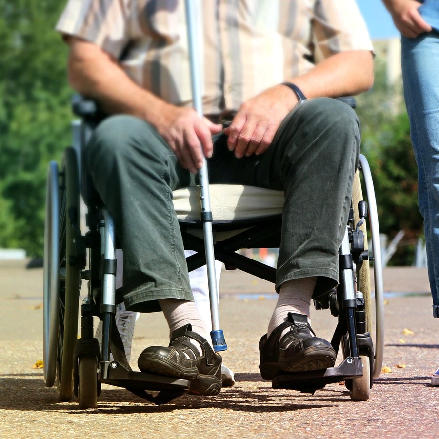 Nærbilde av en rullestolbruker som sitter i rullestolen sin