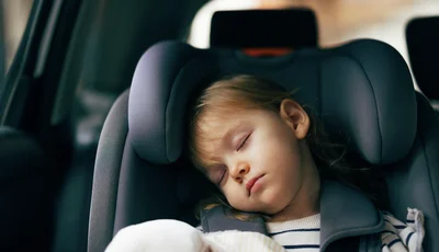 Barn som sover i bilbarnstol