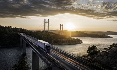 Volvolastbil kör över bro i solnedgången