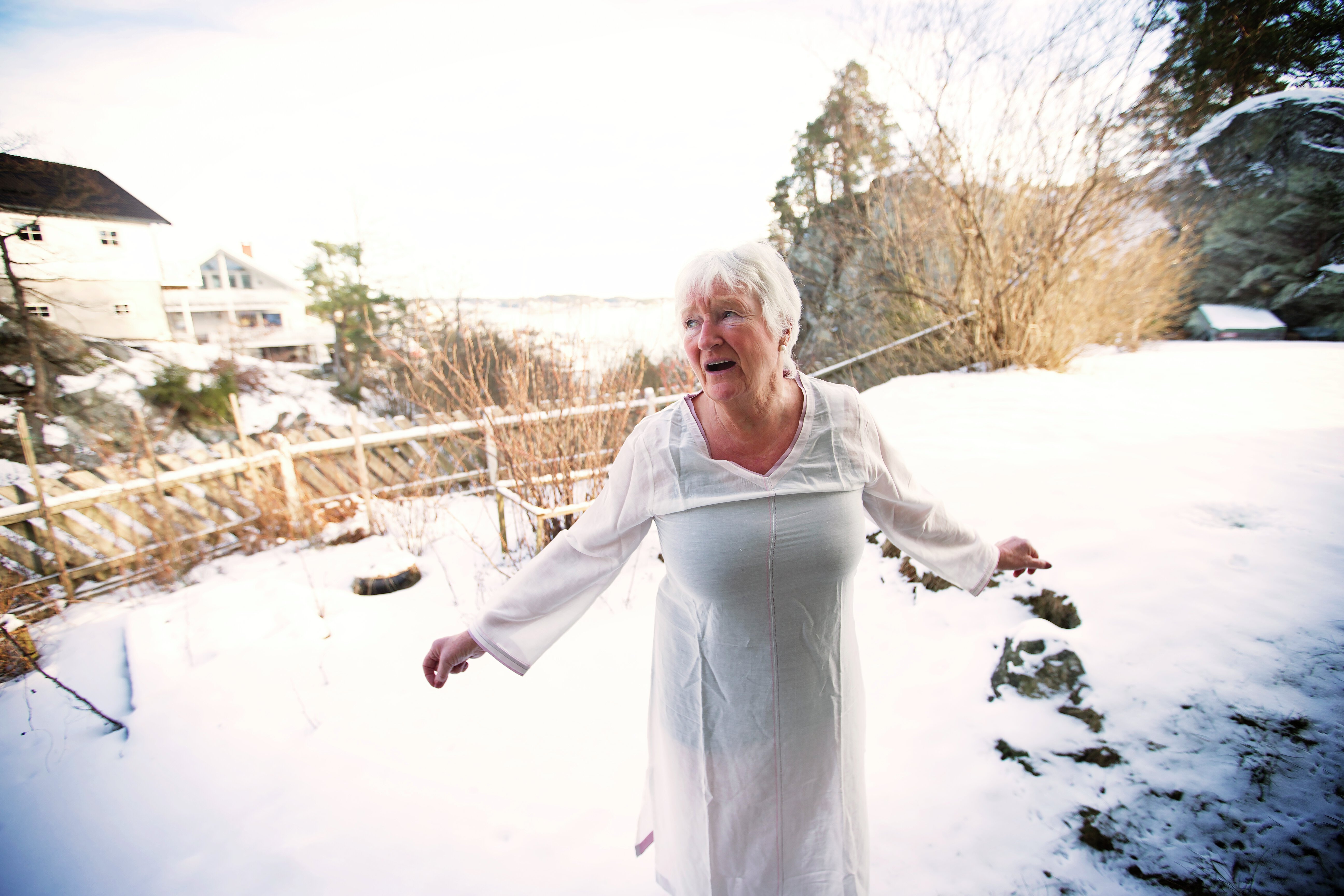 Eldre kvinne uten yttertøy ute på vinteren. Foto