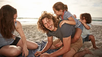 Familj leker på stranden
