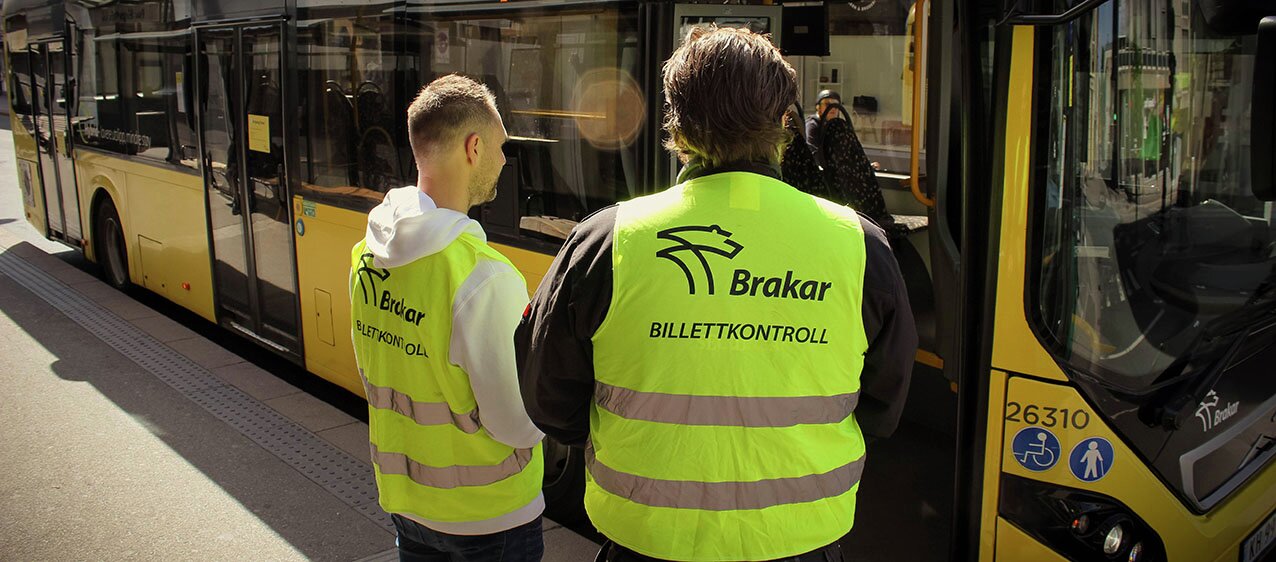 Picture of ticket inspectors in front of a bus.