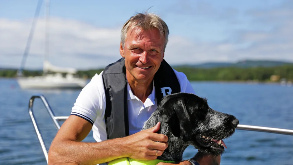 Atle C. Strøm om bord på en båt med hunden sin Sting