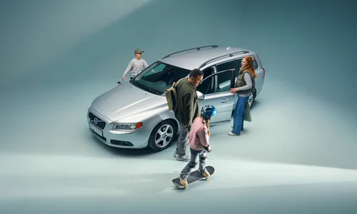 Familj på väg in i en silvrig Volvo V70