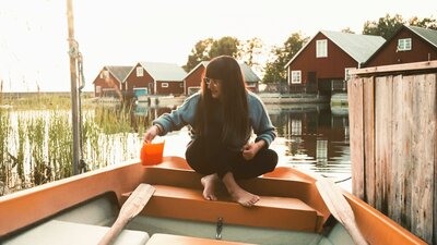 Nainen istuu soutuveneessä