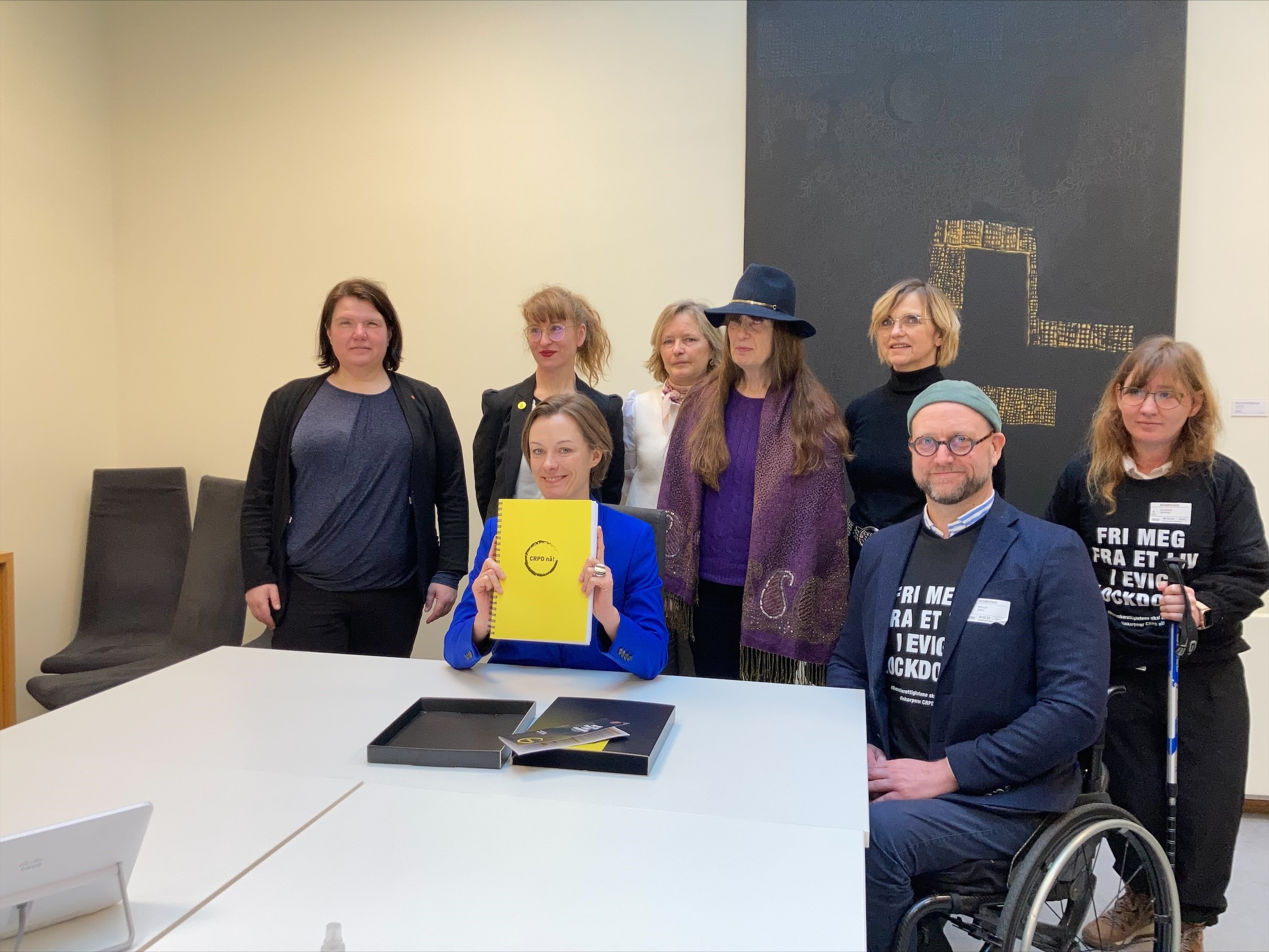 Anette Trettebergstuen med signaturlisten "CRPD nå!", blant representanter for funksjonshemmedes organisasjoner