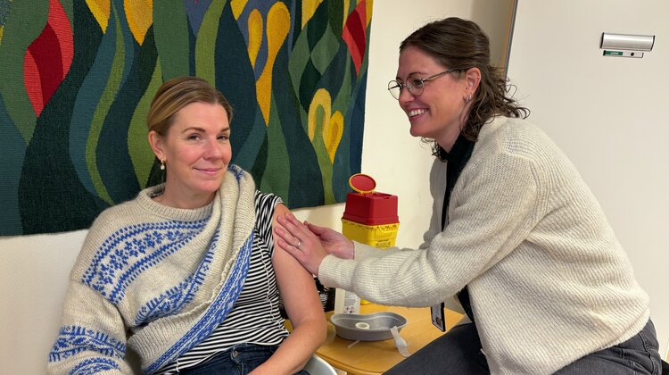 Illustrasjon av helsesykepleier som gir vaksine