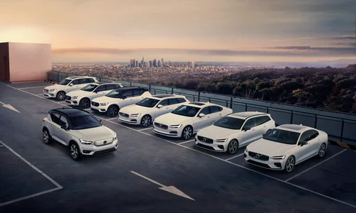 Försäkring företagsbil - Åtta vita Volvobilar parkerade på taket av ett parkeringshus