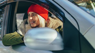 Kvinna i bil på vintern