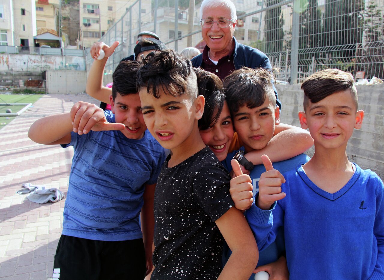 Den pensjonerte læreren Abdallah Hamdan sammen med noen av gutta han hjelper etter skoletid.