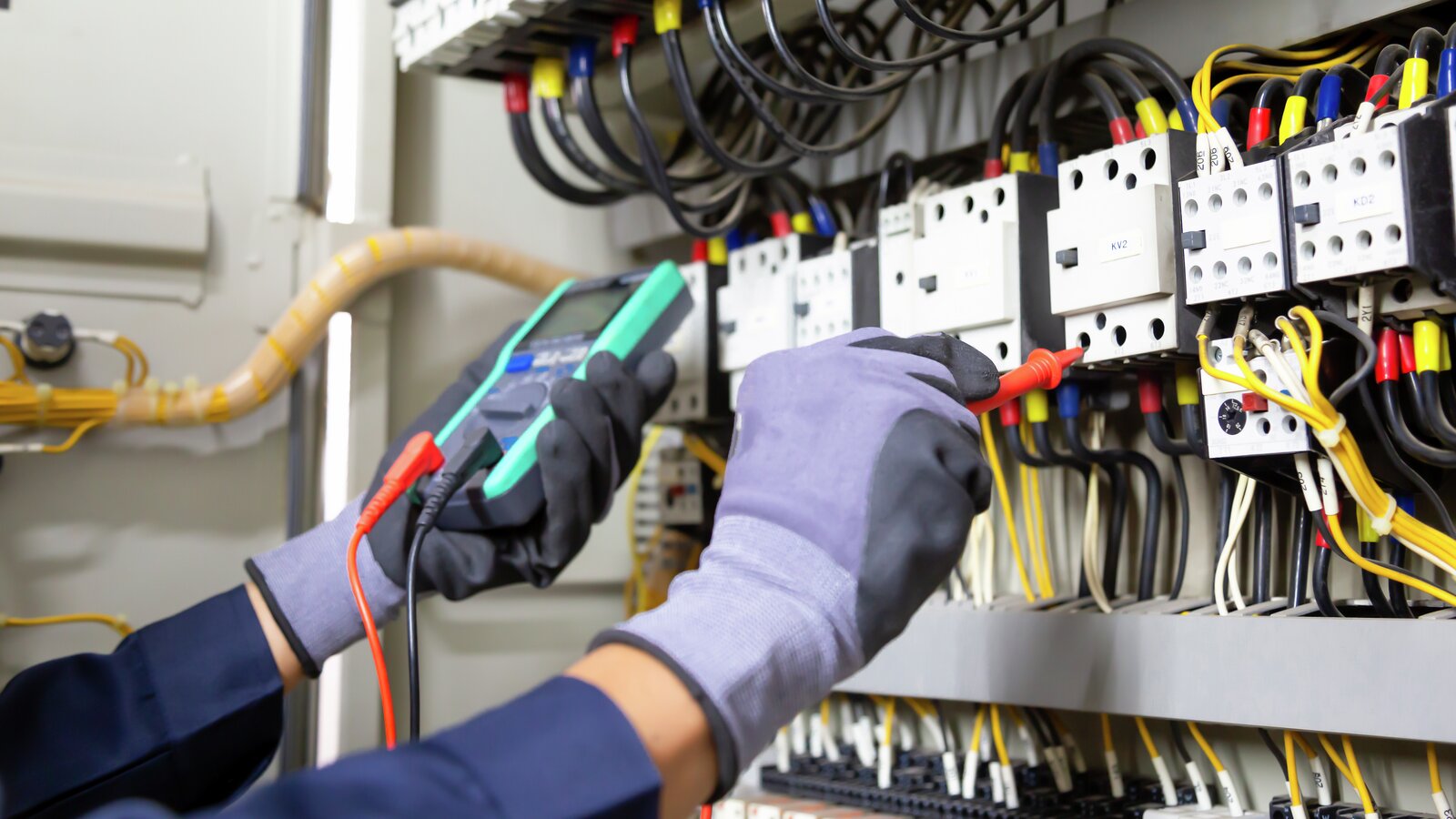 Elektrikeringeniør tester elektriske installasjoner og ledninger på relébeskyttelsessystem. Justering av skjema for automatisering og kontroll av elektrisk utstyr.