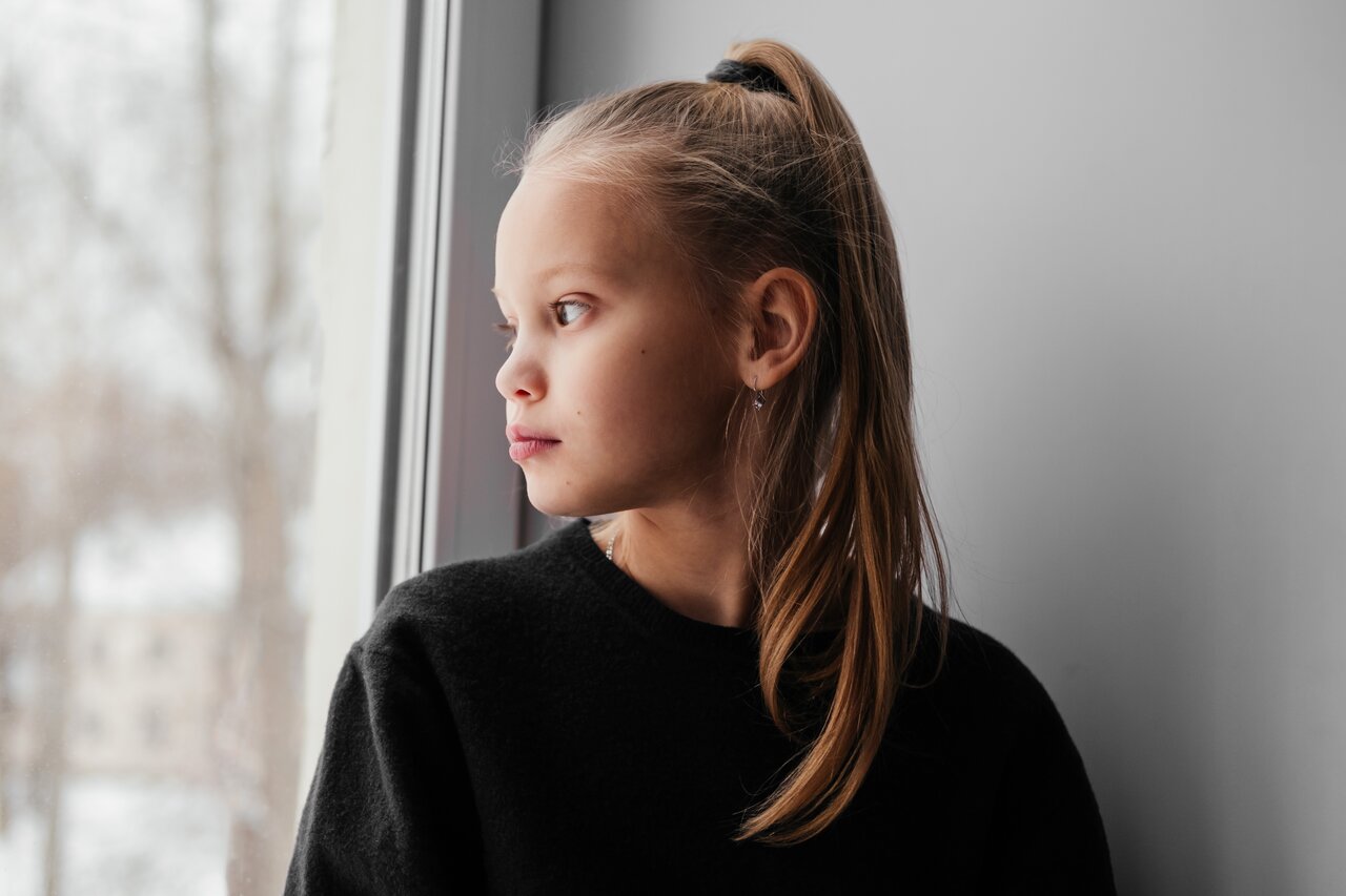 Bilde av en jente som ser ut av vinduet