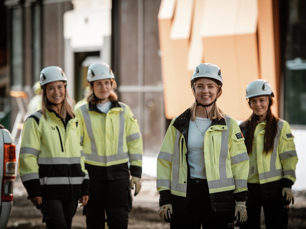 Fire kvinner i verneutstyr på byggeplass 