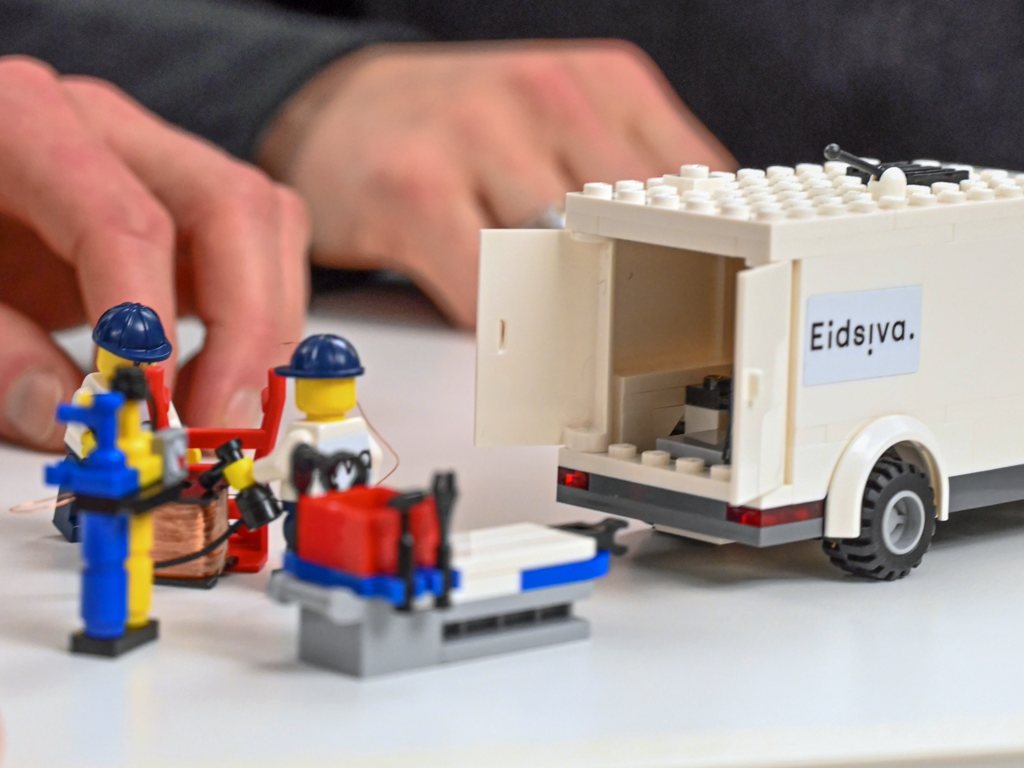 Legomen bærer en lego pasient inn i legoeidsivabilen