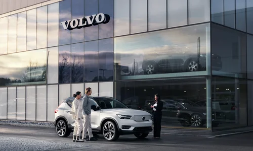 Kvinne og mann står ved Volvo XC40 utenfor Volvo-forhandler
