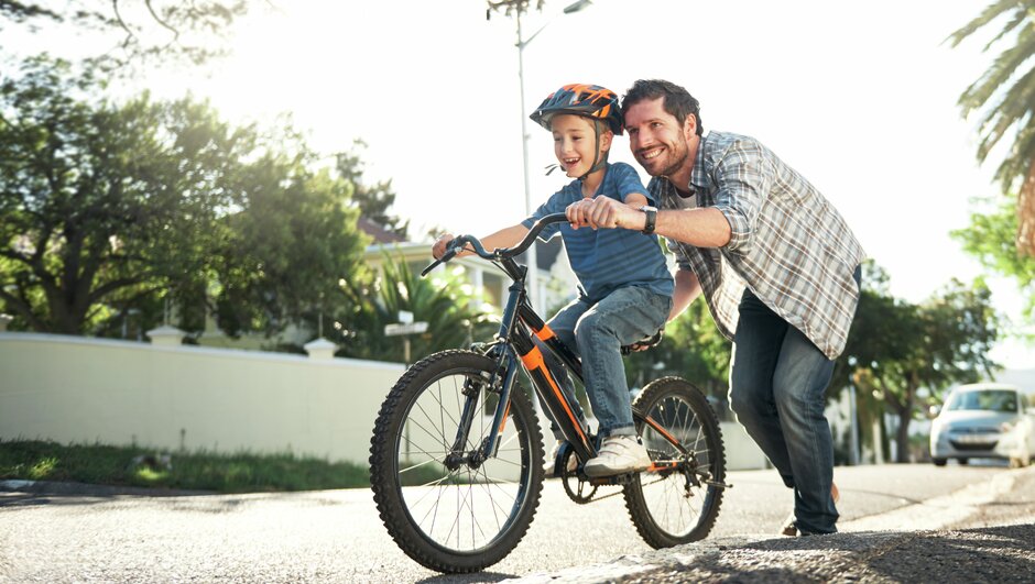 pojke får hjälp av pappa att cykla
