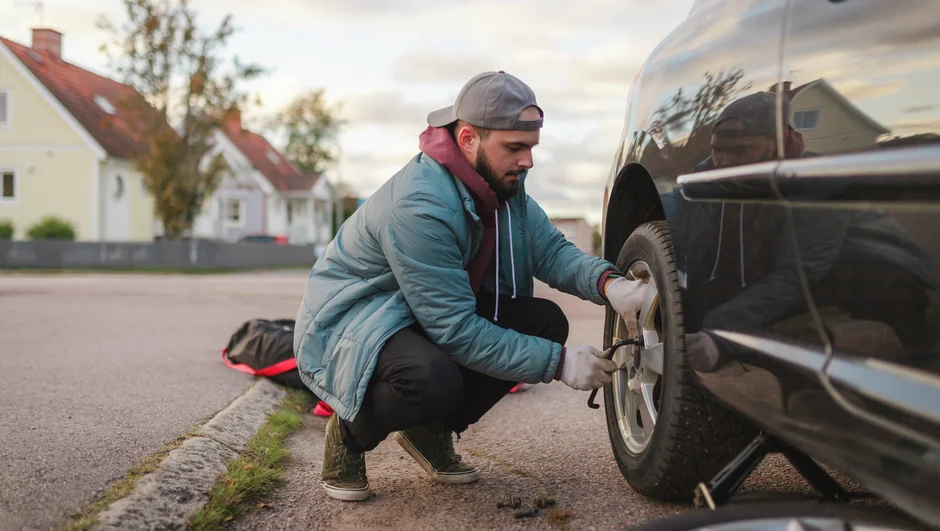 Mand skifter et hjul på sin bil