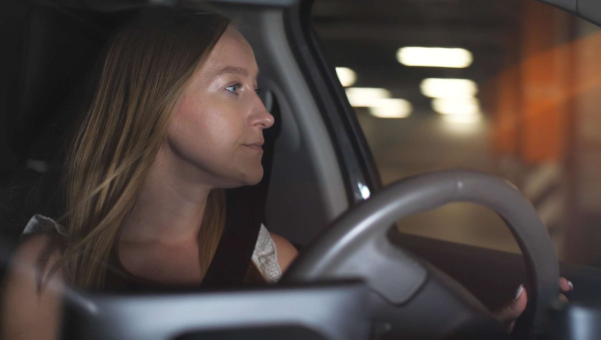 Bilforsikring Kvinne som kjører bil og ser ut av vinduet