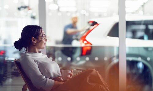 Kvinne sitter i stol hos bilforhandler