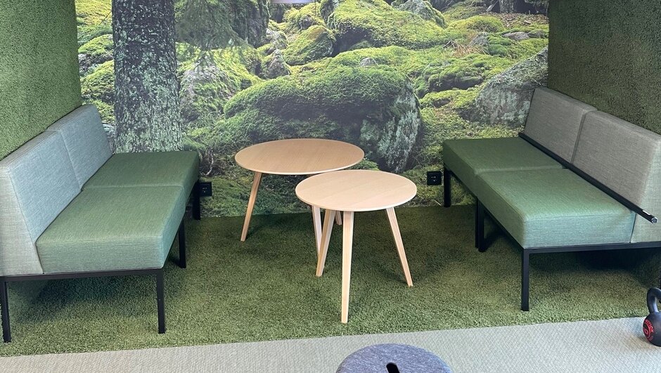 Green seating area with a forest themed wallpaper