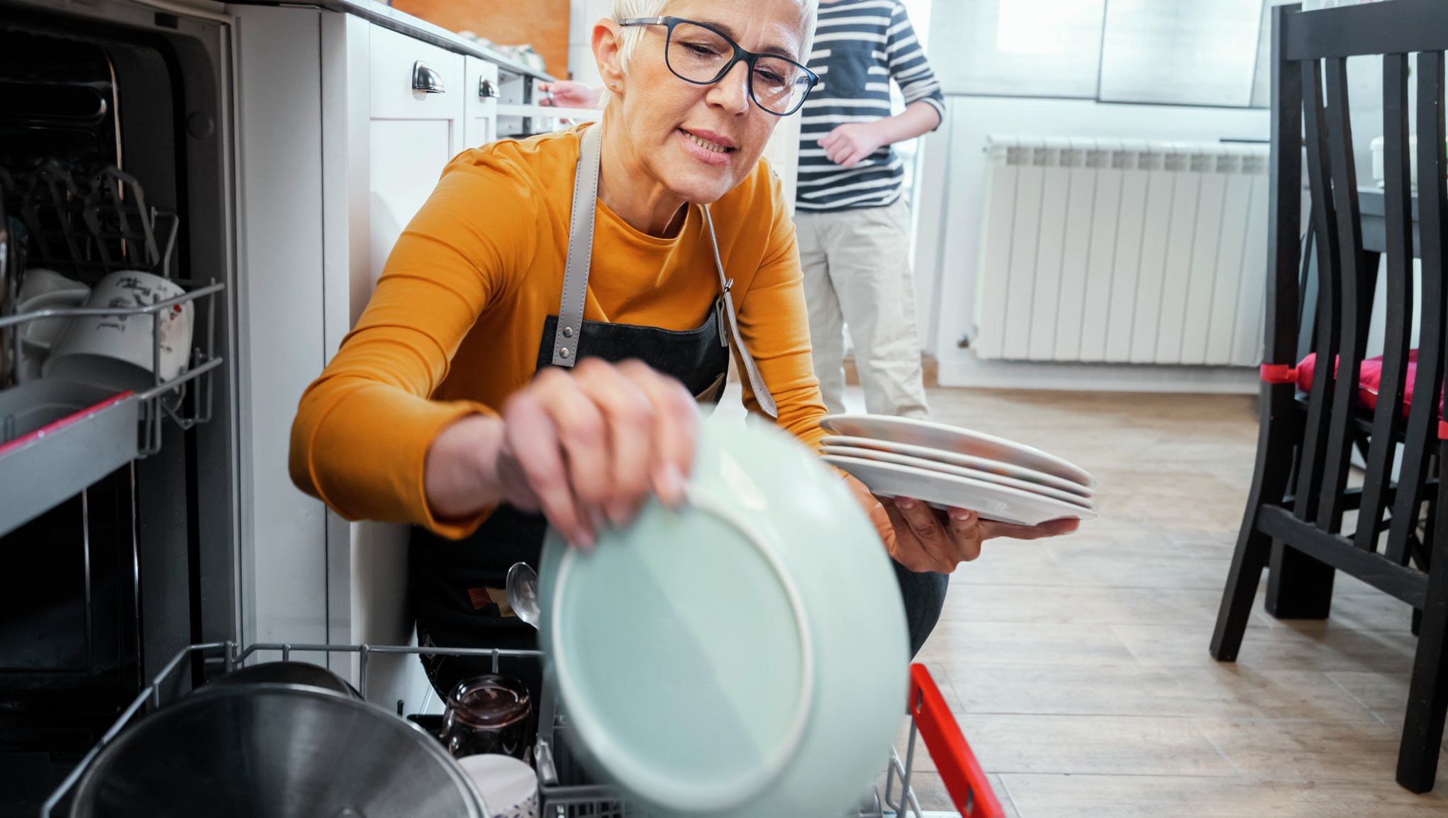 Kvinne setter inn i oppvaskmaskinen