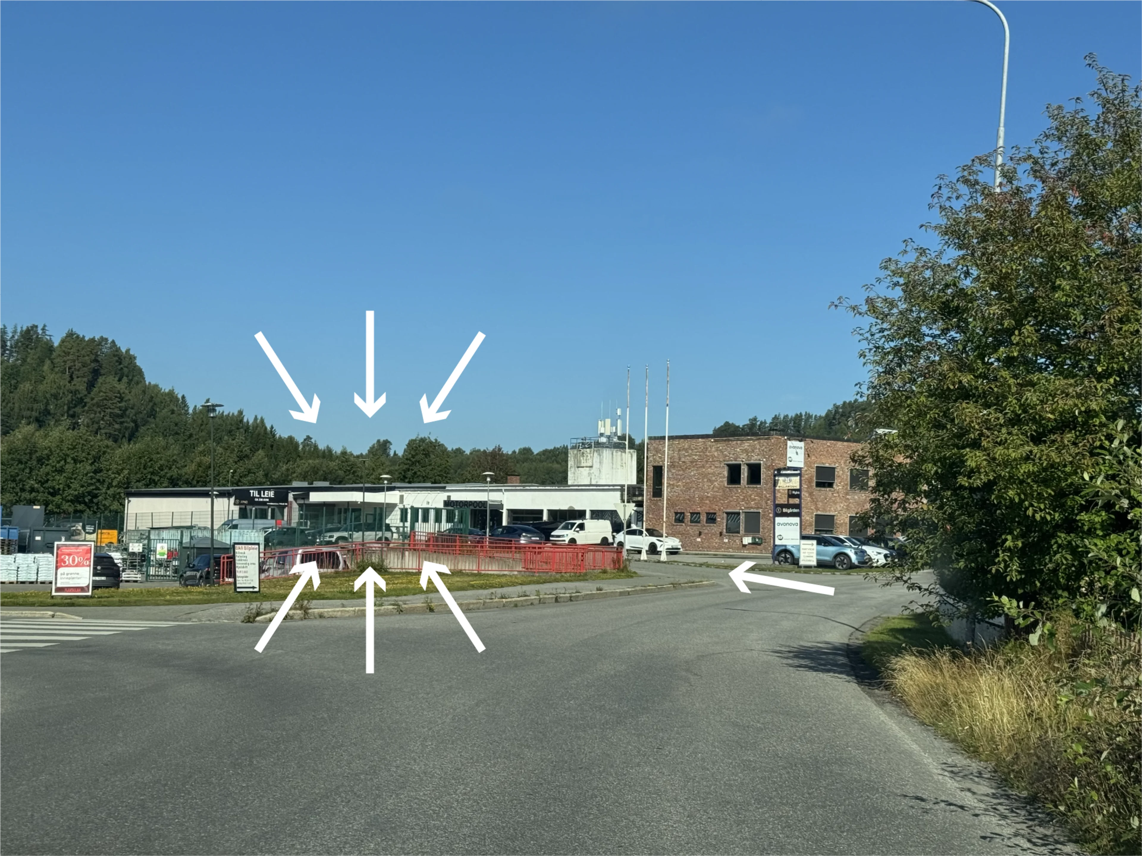 Hvite piler viser hvor MOVA Eikli ligger i det hvite næringsbygget ved veien, og hvor du kjører inn.