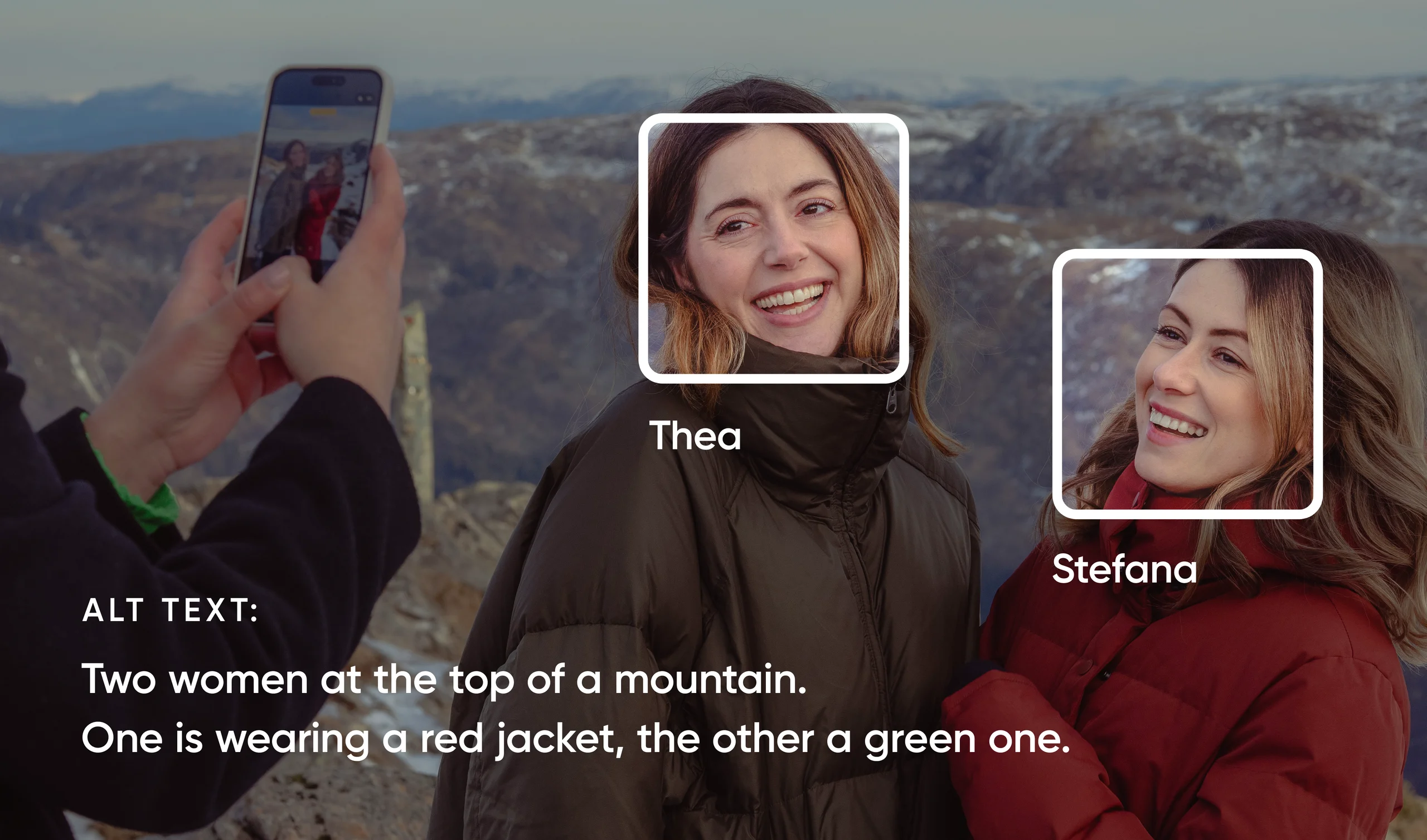 Two women, Thea and Stefana, smile on a mountaintop while someone photographs them with a smartphone.