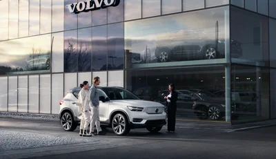 Kvinne og mann står ved siden av Volvo XC40 foran Volvo forhandler