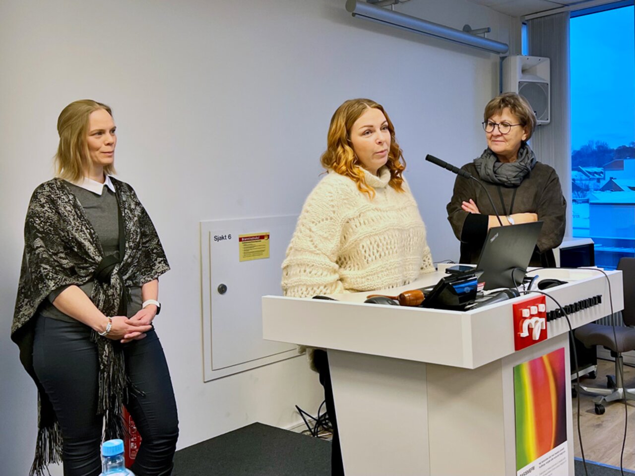 Hege Annette Rovik, Berit Tevik og Mette Nord foran en fullsatt landsstyresal.