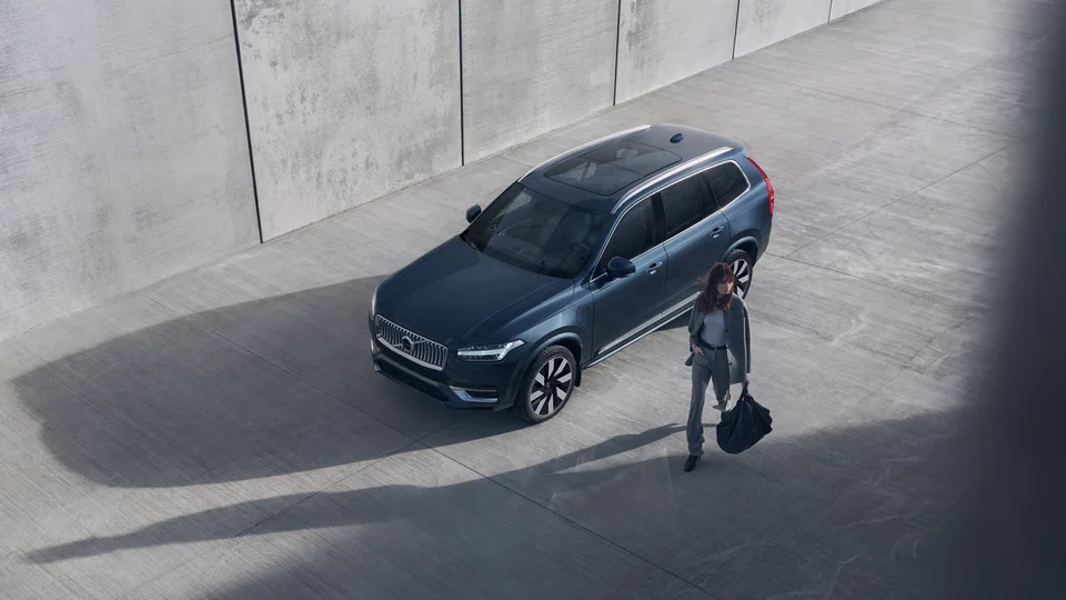 Volvo privatleasing – Kvinna med väska i handen passerar blå Volvo XC90