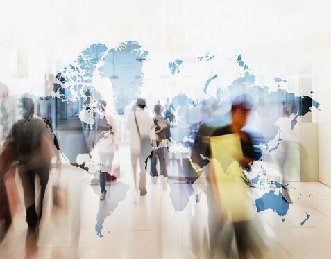 Group of people moving quickly in front of world map, motion blur