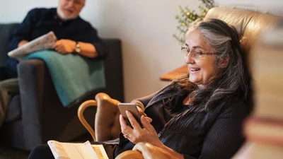 Ældre kvinde sidder med sin telefon