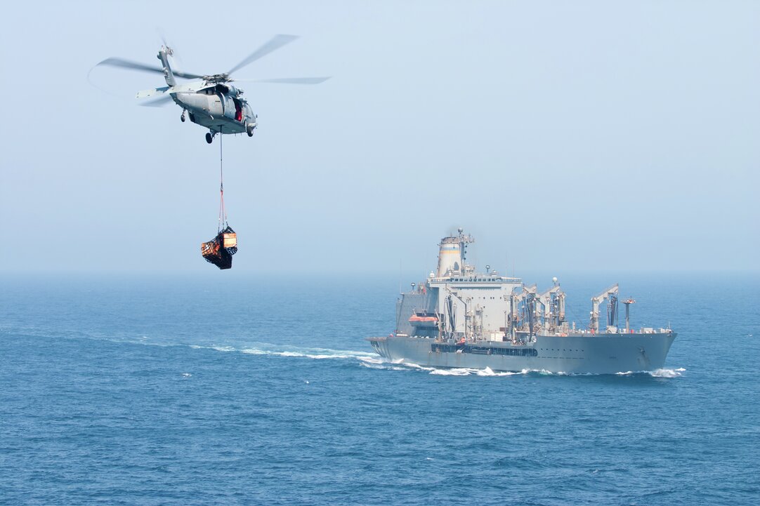 Helicopter bringing supplies to a ship.