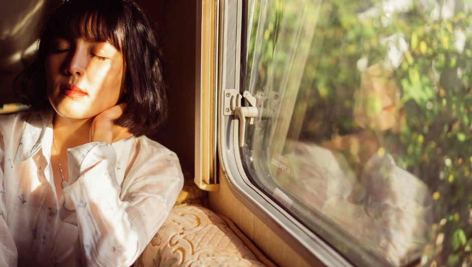 Kvinde sidder ved vinduet i et tog