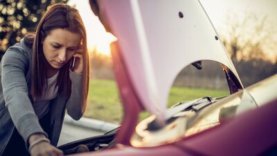 Kvinna tittar under motorhuv