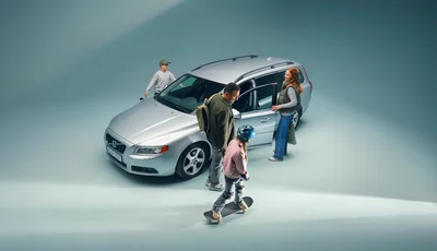 Familj på väg in i en silvrig Volvo V70