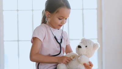 Ung jente lytter til hjertet på kosebamsen sin med et stetoskop
