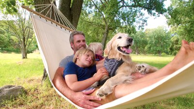 Barnfamilj och hund i hängmattan